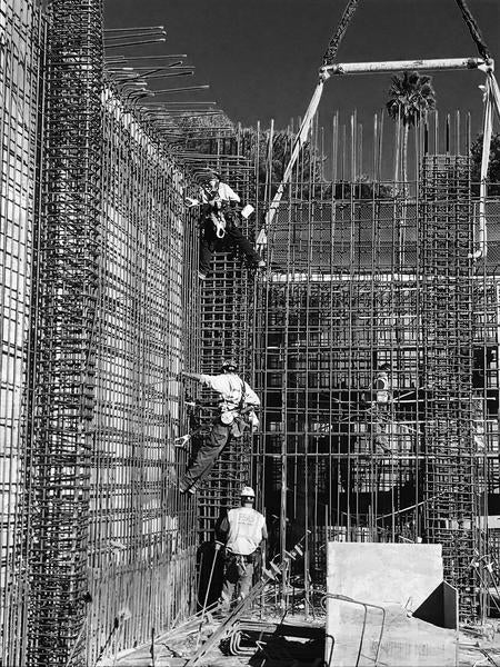 Rod busters tying shotcrete wall rebar